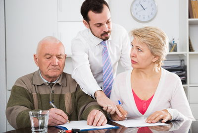 older couple signing papers with lawyer