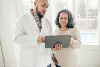 healthcare representative next to an elderly woman looking at a screen