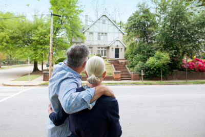 an older couple looking at a house across the street