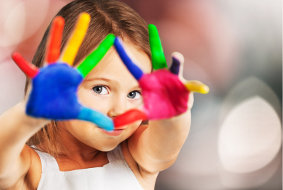a young girl with her hands faced to the camera, colorfully painted