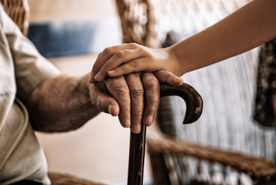 a younger person holding an elderly persons hand